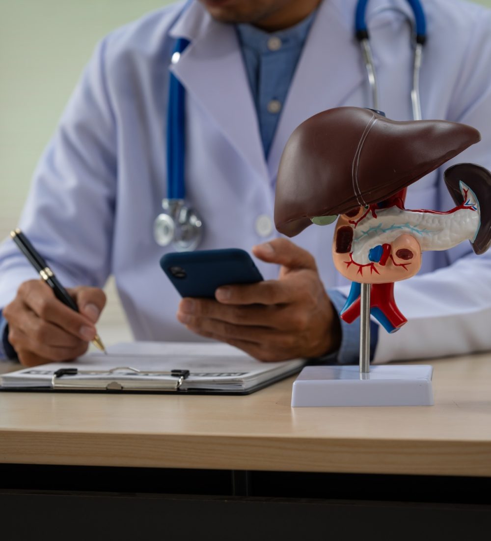 A male doctor sits at a table in a liver disease clinic, giving online advice on hepatitis A male doctor sits at a table in a liver disease clinic, giving online advice on hepatitis