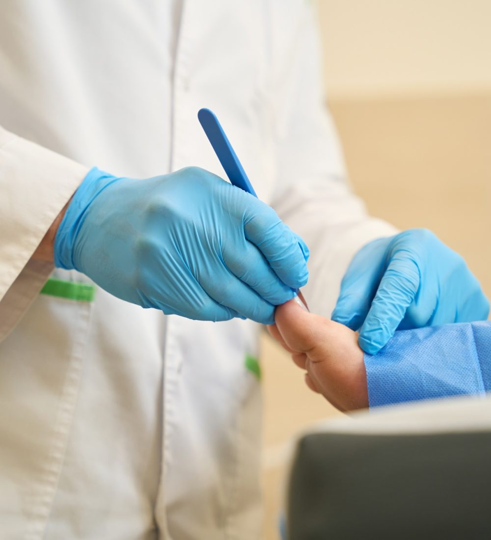 Podiatrist performing toenail surgery on adult person Podiatrist performing toenail surgery on adult person