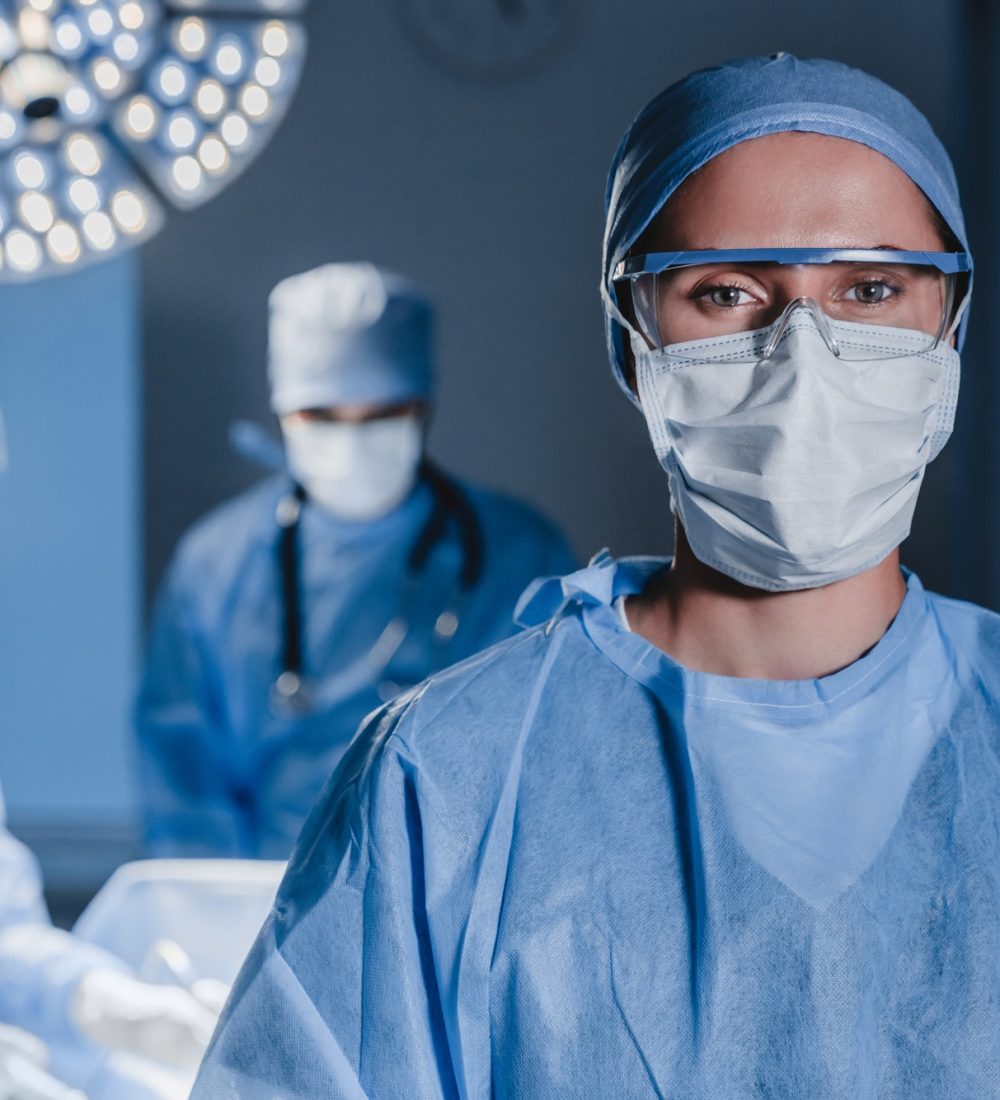 Portrait of young female surgeon doctor surrounded by her team. Group of surgeon Portrait of young female surgeon doctor surrounded by her team. Group of surgeon